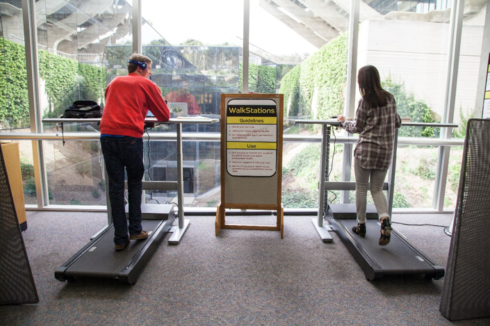 Two students on WalkStation treadmills.